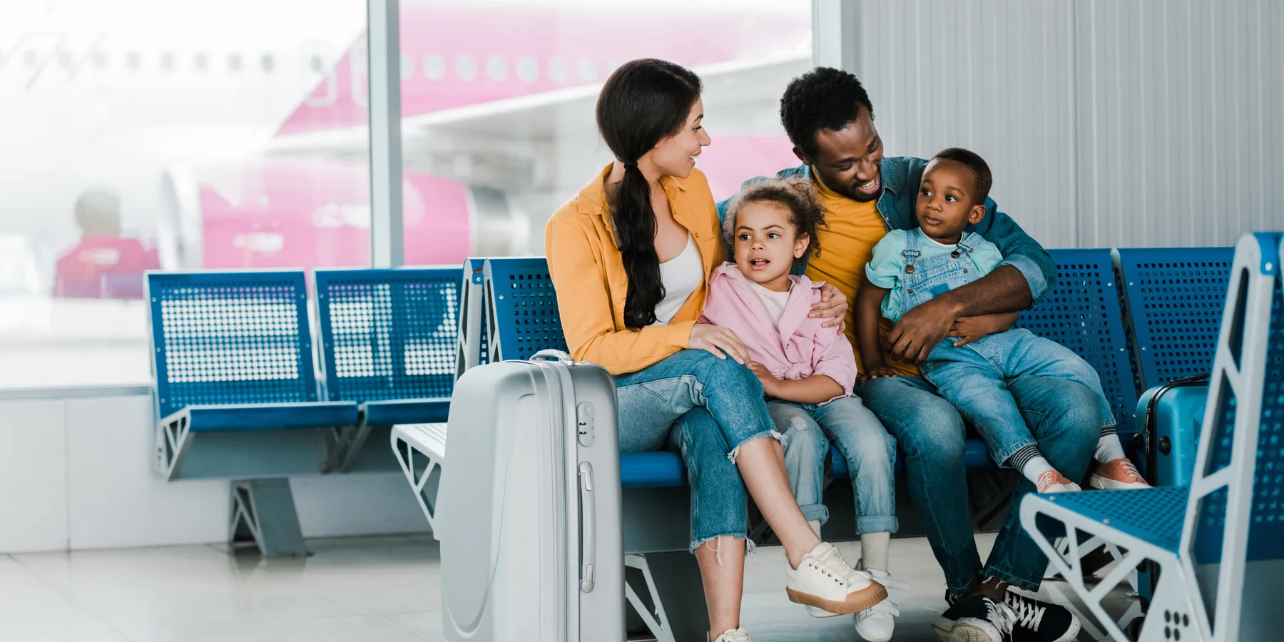 Family with two young children waiting in an airport departure lounge