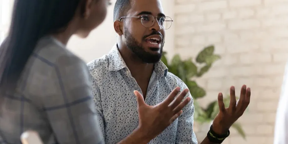 Man in glasses explaining an idea to a colleague in a meeting