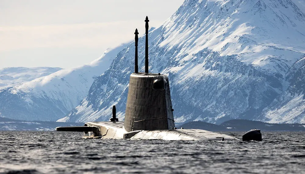 Submarine surfacing in icy waters beneath snow-covered mountains