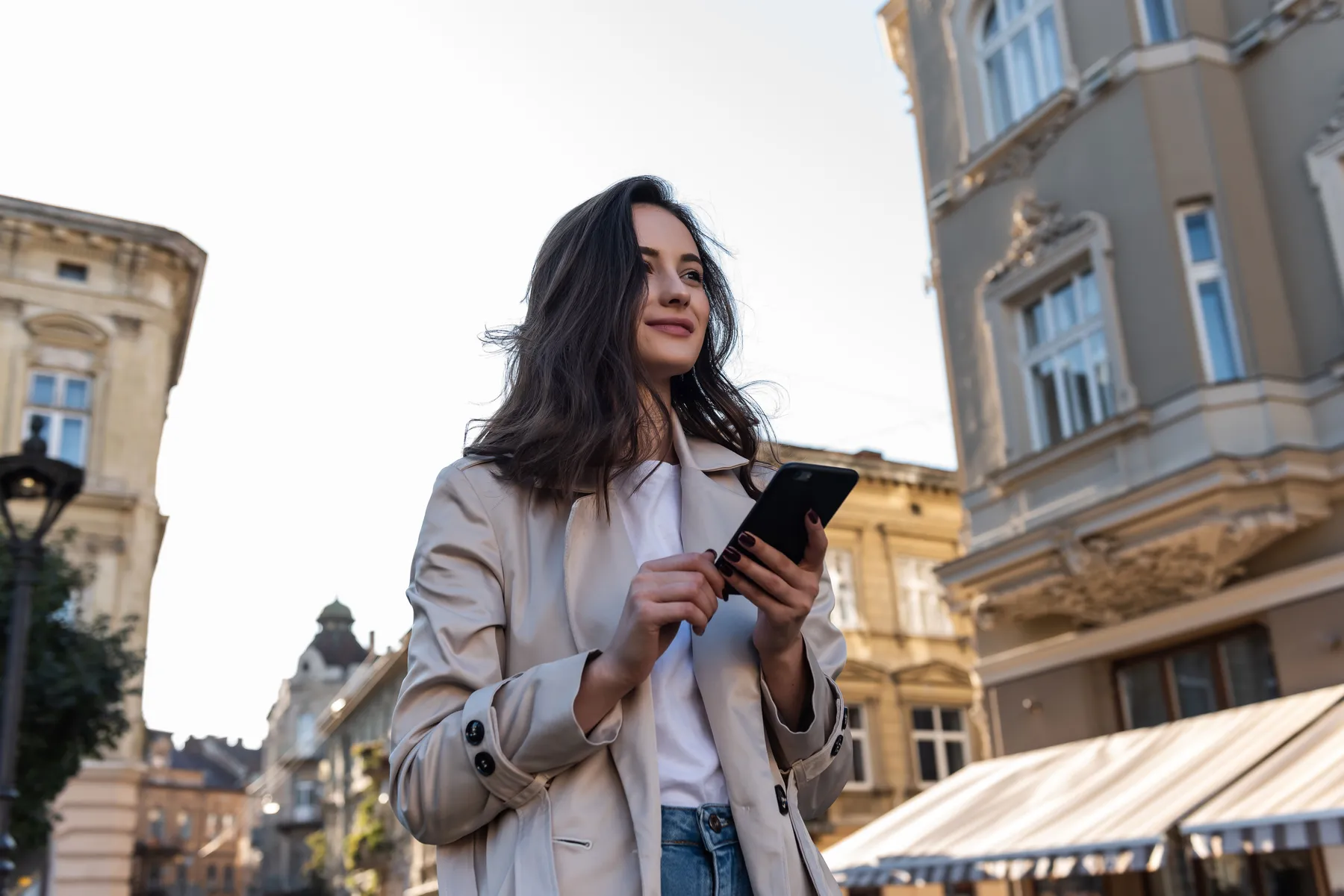 Woman holding a smartphone on a city street